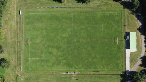 Aerial-top-view-of-an-empty-soccer-field-green-grass-sport-France-drone-sunny